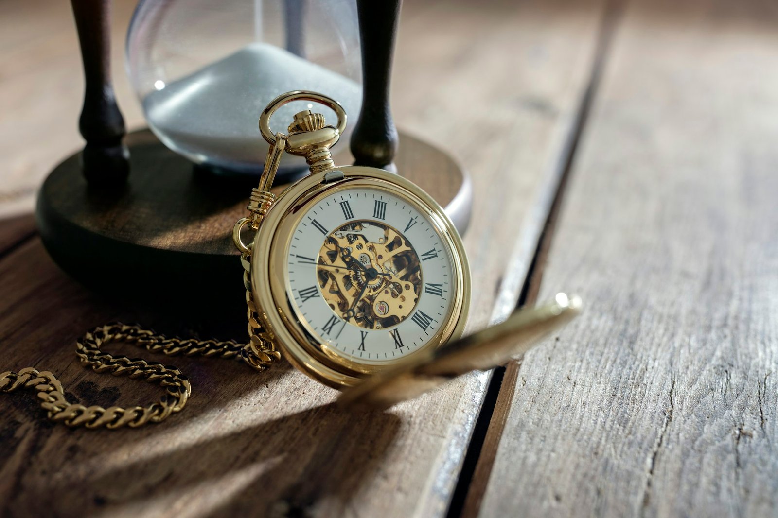 Gold pocket watch and hourglass