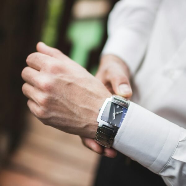 Man in white shirt wearing classic silver watches. Getting ready for wedding
