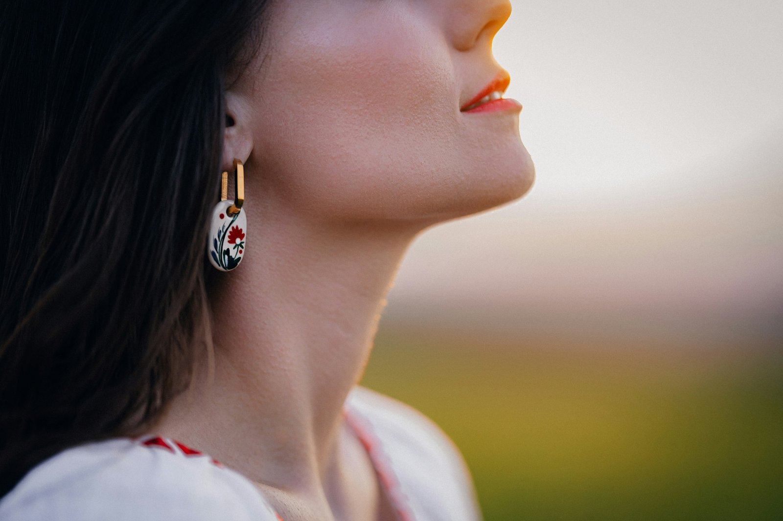 Young woman with ethnic earring and shirt with traditional ornaments breath free